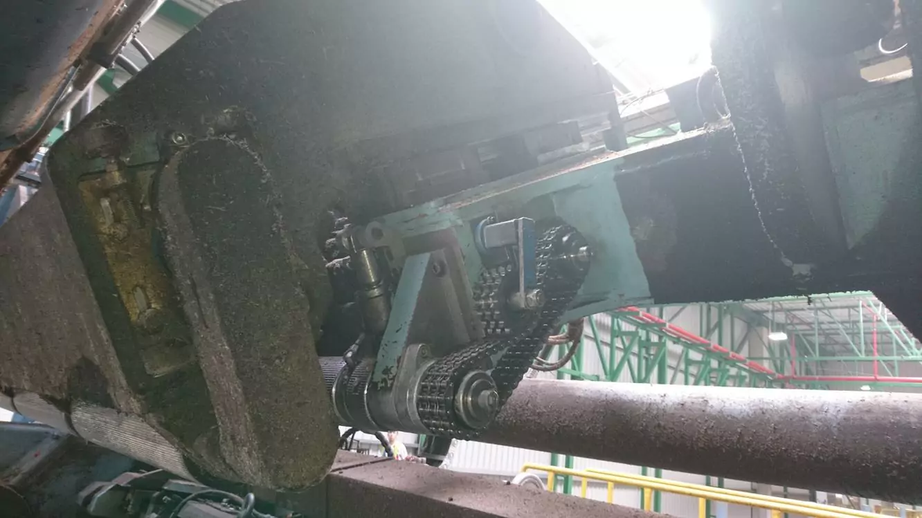 Przemysł drzewny 7 Zbliżenie na maszyny przemysłowe z metalowymi łańcuchami, kołami zębatymi i rolkami z widocznym kurzem i brudem, ustawione w środowisku fabrycznym - idealne dla Czyszczenie Maszyn Stolarskich Suchym Lodem, aby przywrócić wydajność i czystość.